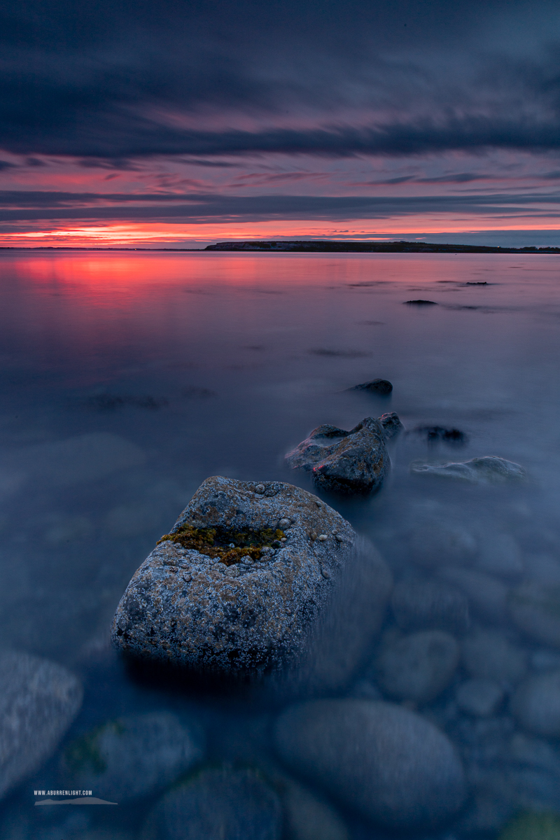 Rock formations reflected in calm twilight waters