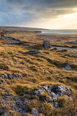 Low winter sun illuminating karst grassland and scattered limestone boulders near Fanore, County Clare.