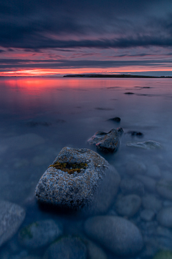 Rock formations reflected in calm twilight waters